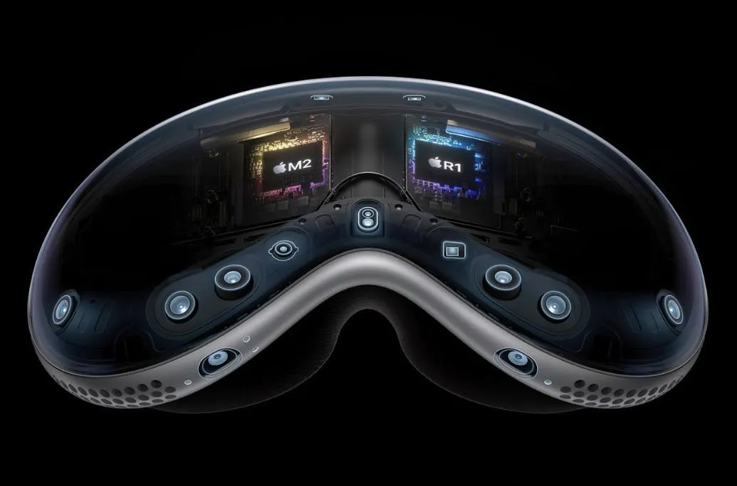 Product image of the Apple Vision Pro headset, its sensor array and M2 and R1 chips highlighted