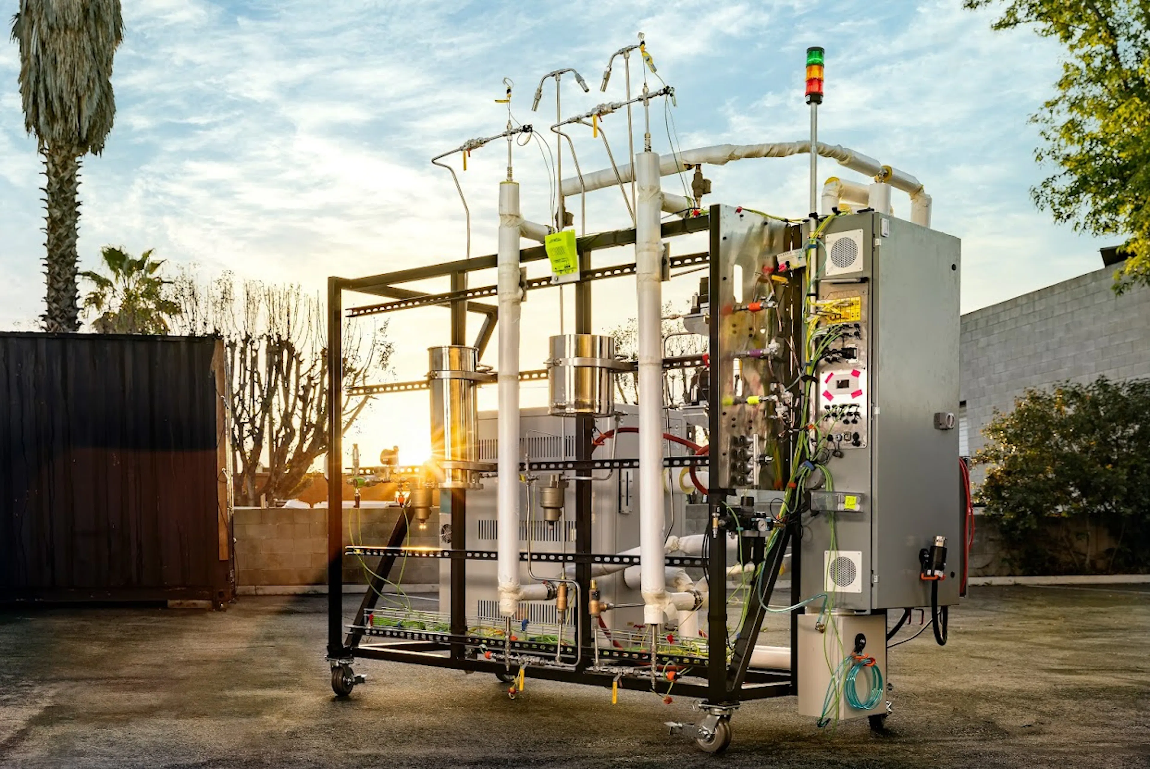 Terraform Industries' Sabatier reactor, a metal-framed unit on casters with vertical reactor tubes, gas lines, and a control cabinet, photographed outdoors at sunset