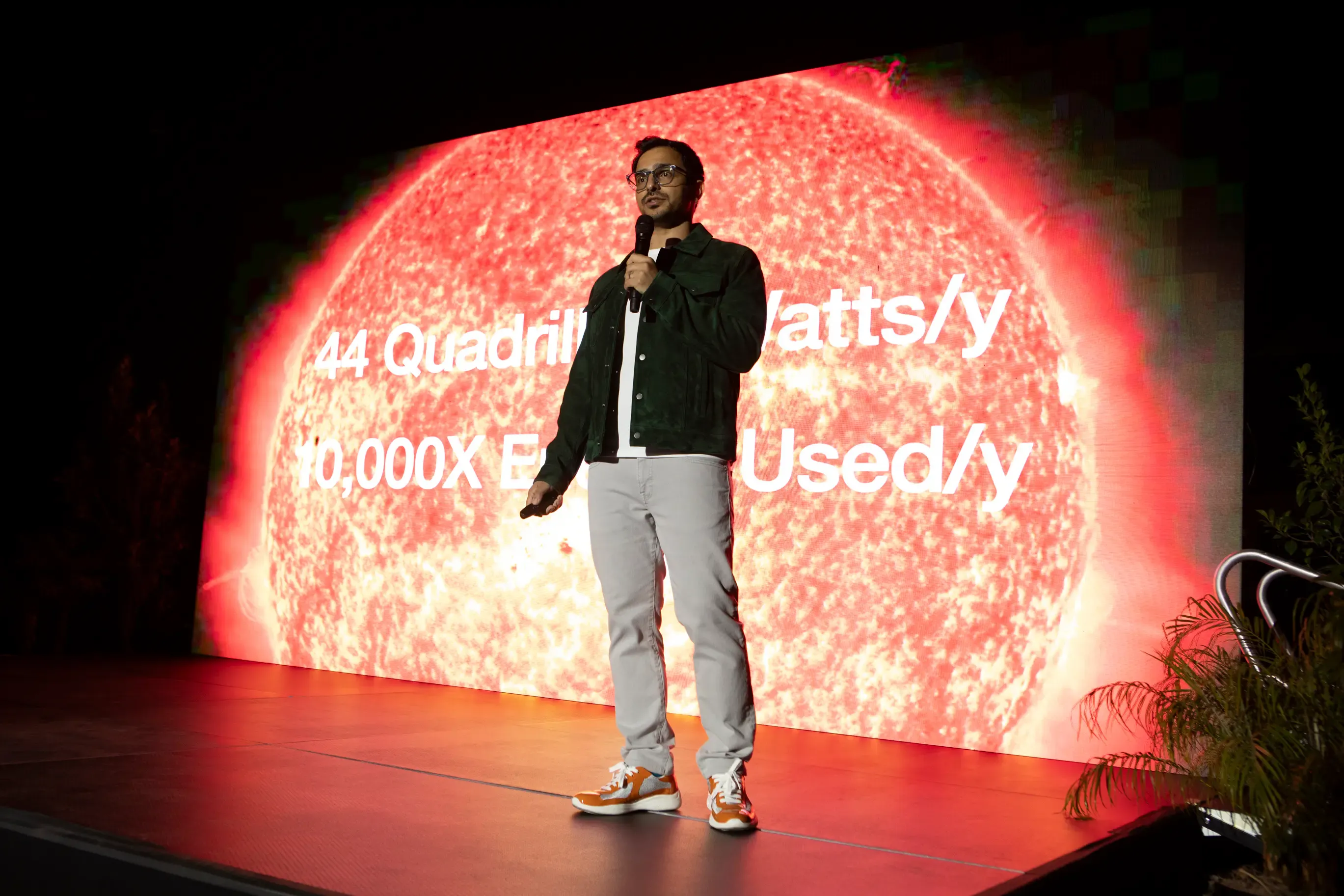 Exowatt CEO Hannan Happi speaking on stage in front of a screen showing the sun's annual energy output