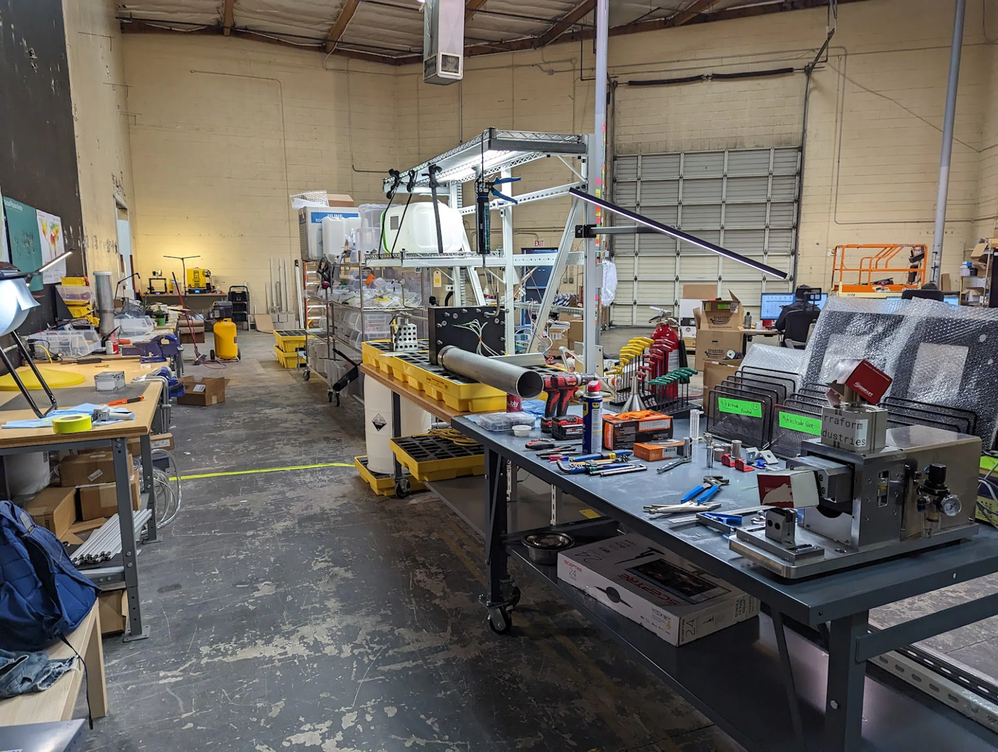 Terraform Industries' Burbank workshop with an electrolyzer test frame, workbenches, tools, and injection-molded parts