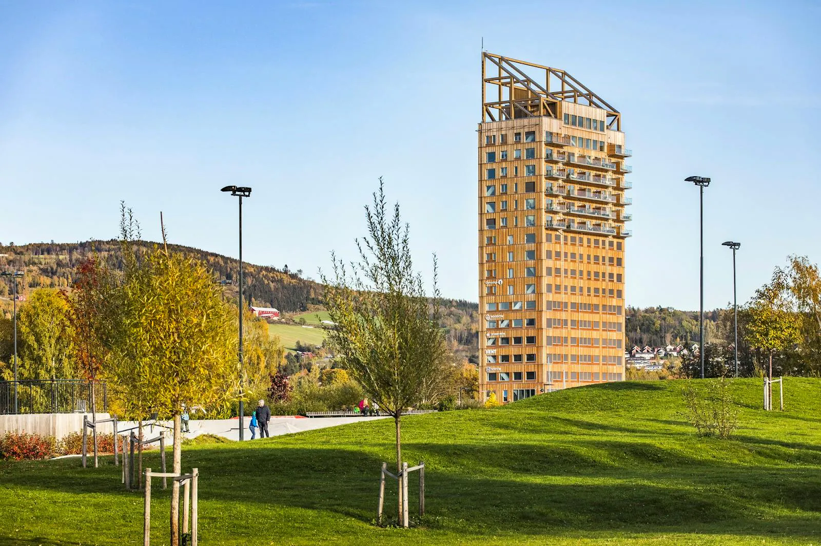 Photograph of Mjøstårnet, a tall timber tower rising above trees and parkland