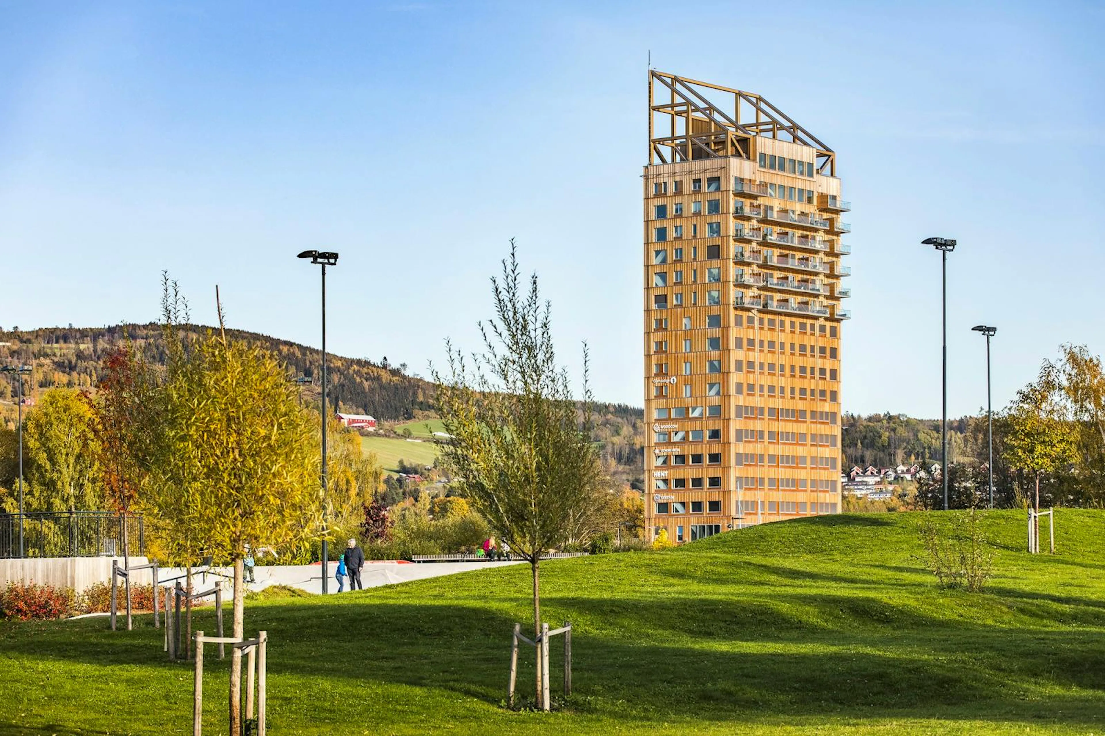 Photograph of Mjøstårnet, a tall timber tower rising above trees and parkland