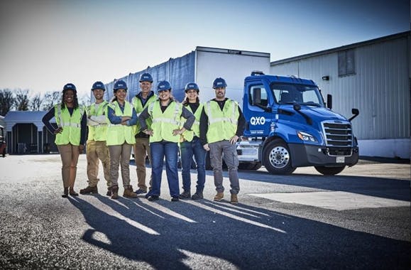 QXO employees in front of a distribution truck