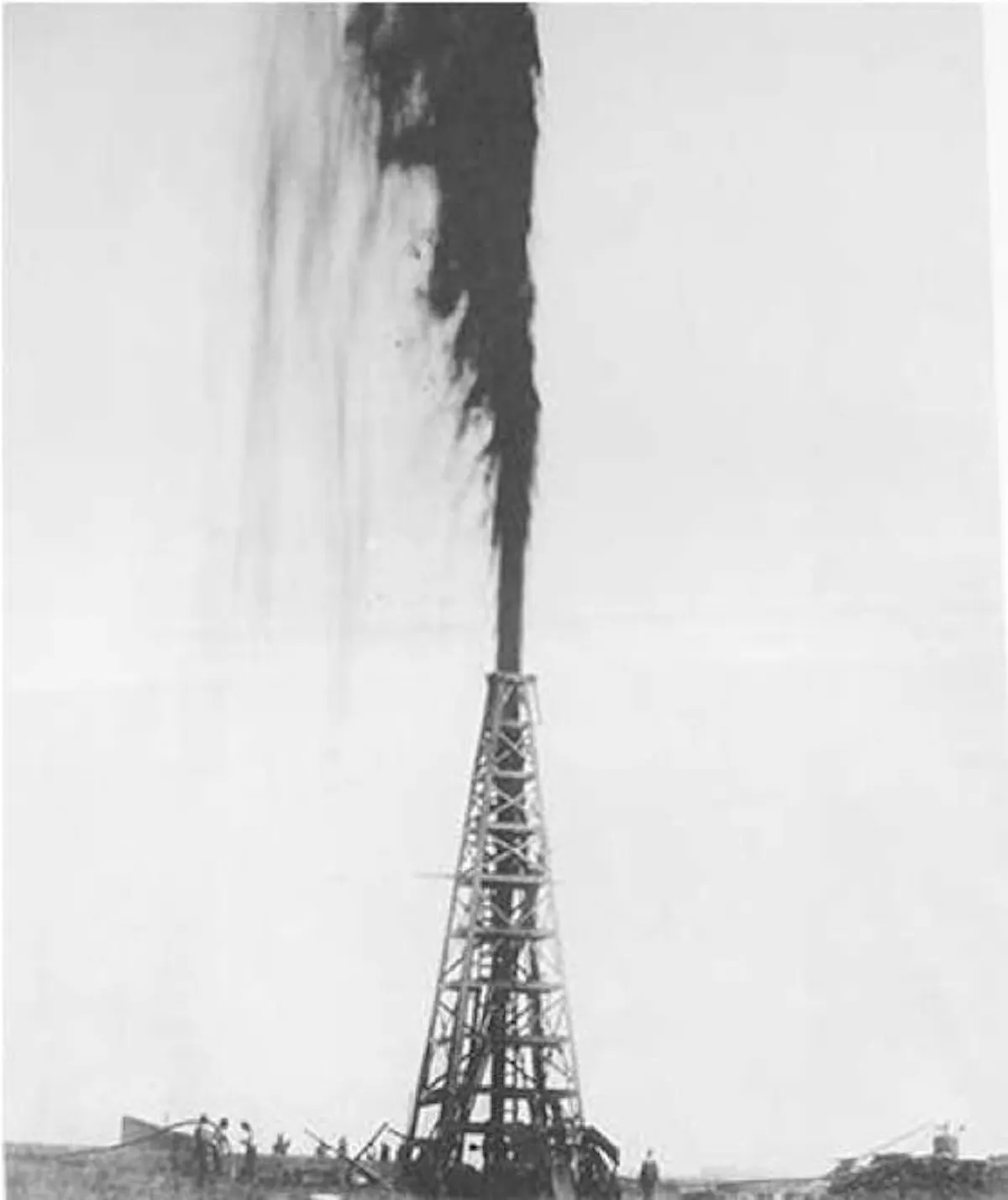 Black-and-white photograph of the Spindletop gusher, a column of oil blowing high above a wooden derrick