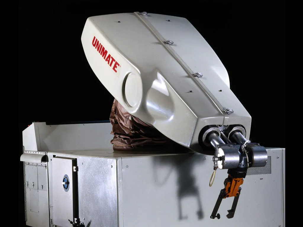 Photograph of the Unimate, the first industrial robot, its arm extending from a boxy cabinet
