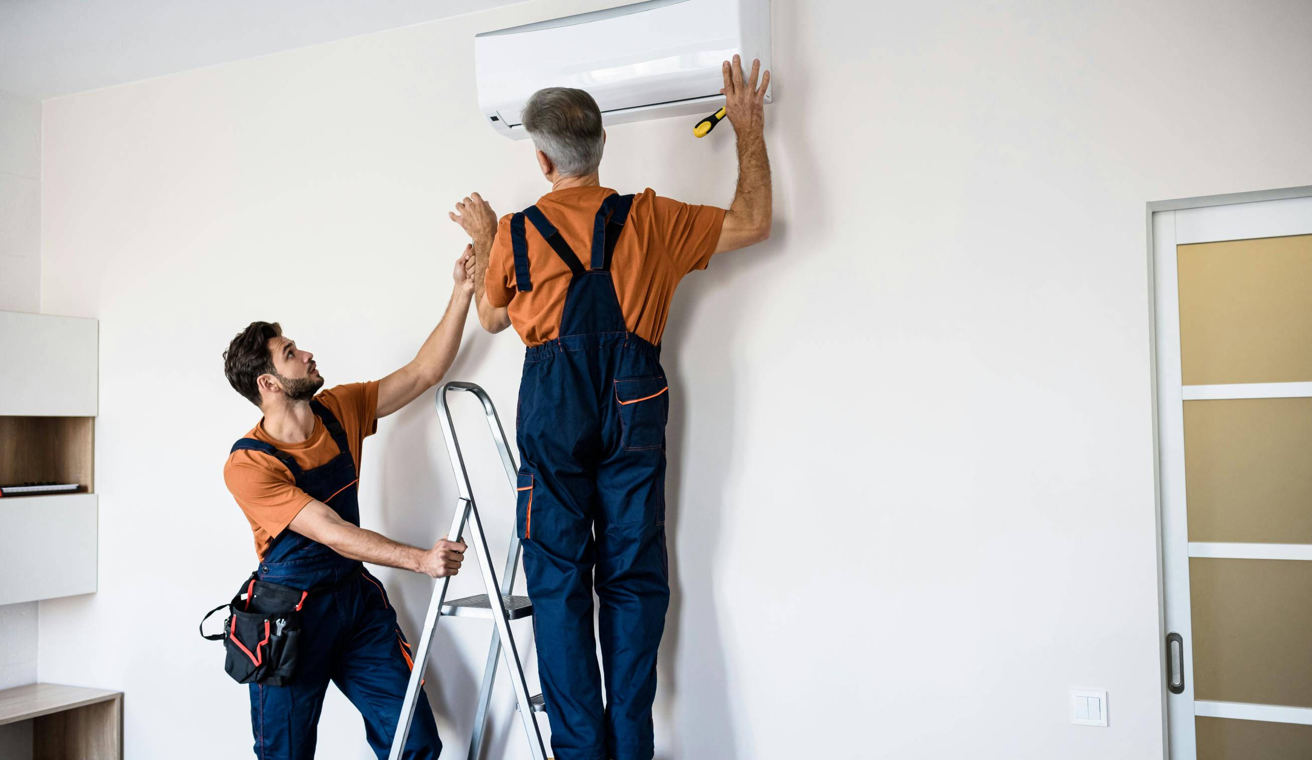 Equipo de instaladores instalando aire acondicionado