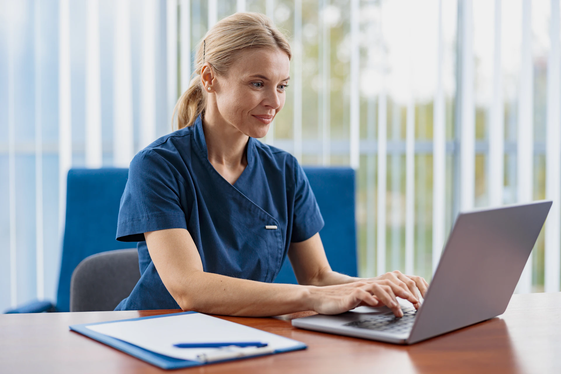 Medizinische Fachkraft sitzt am Laptop und arbeitet