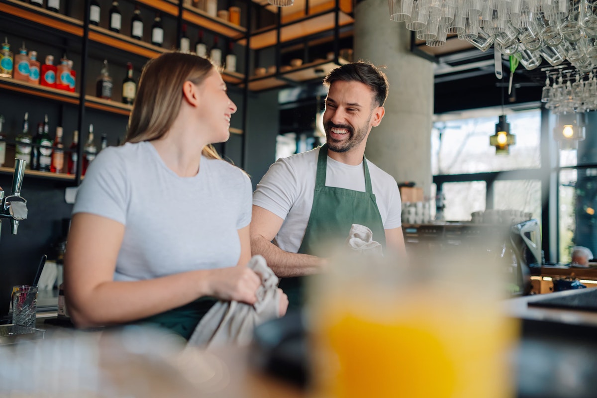 two people working together behind the bar in a restaurant