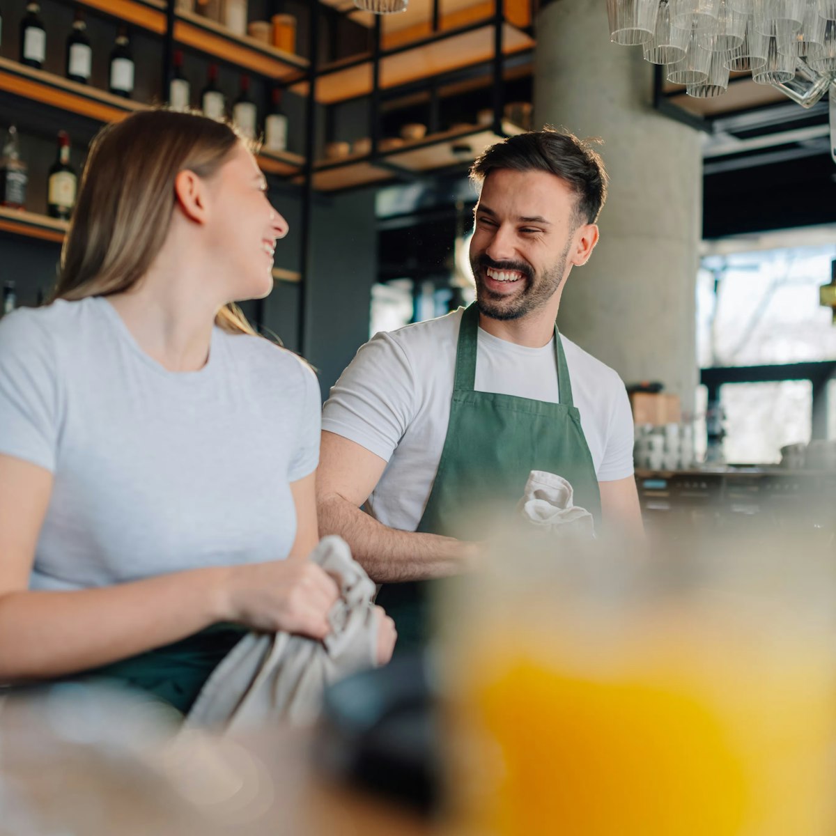 two people working together behind the bar in a restaurant