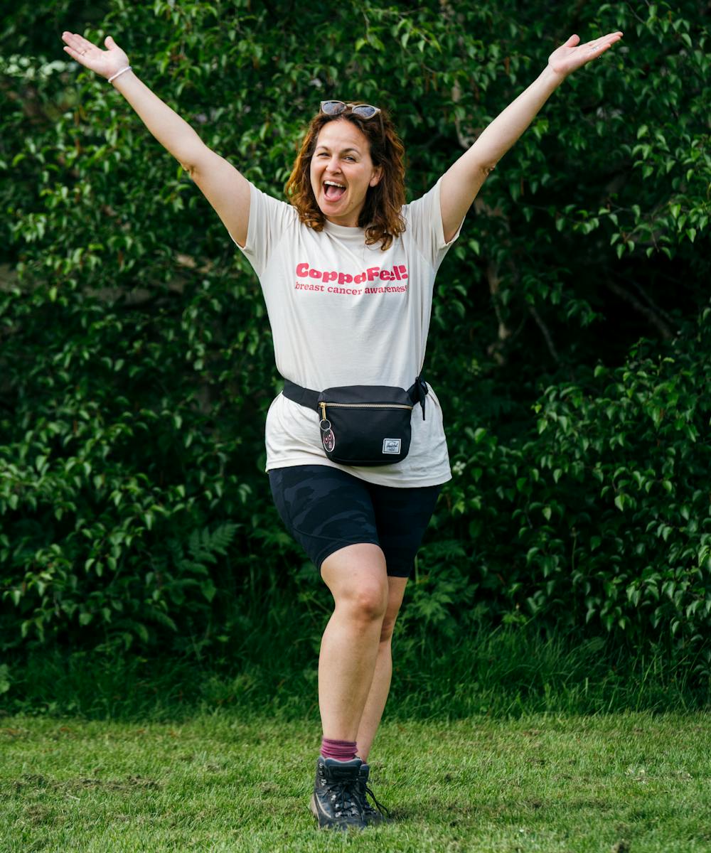 Photo of GI smiling with arms outstretched, wearing a CoppaTrek t-shirt.