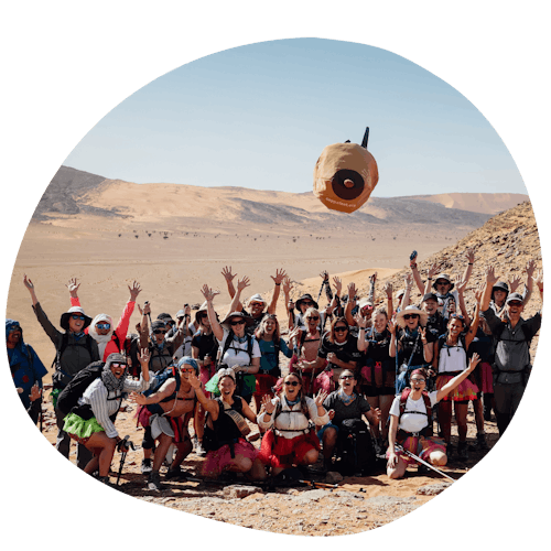 Sahara trekkers smiling and waving in the desert