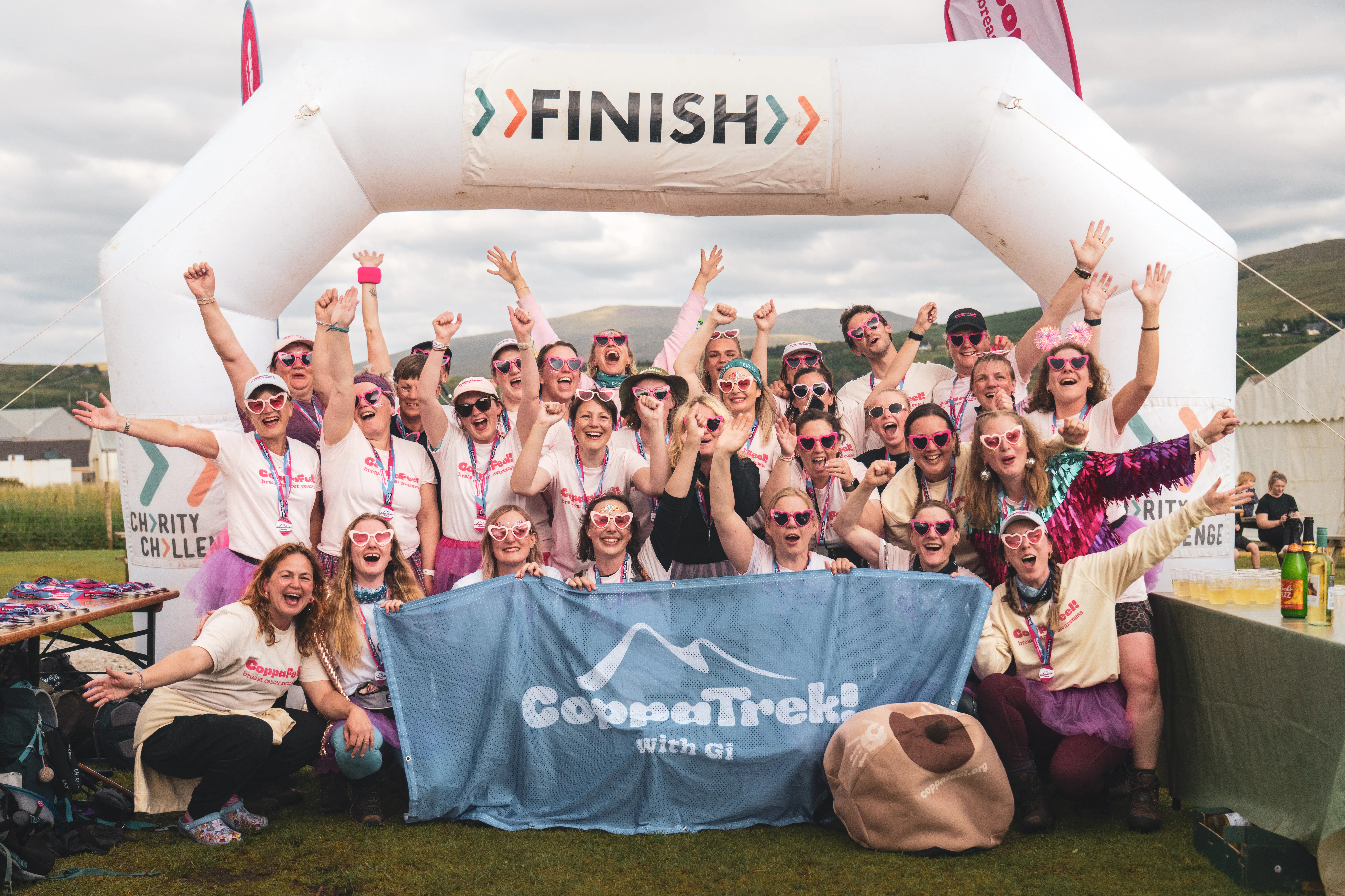 Large group of trekkers celebrating at the finish line.