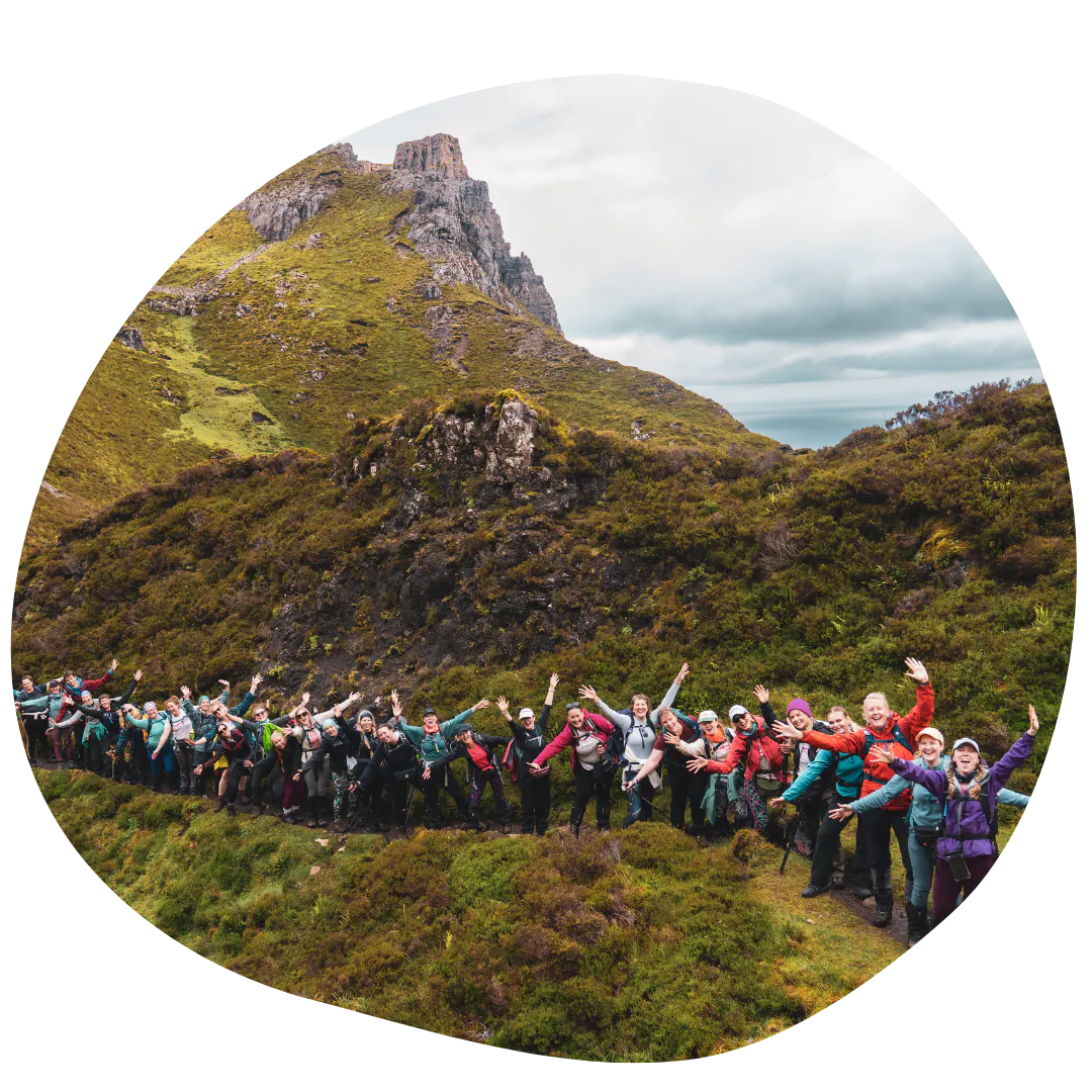 Trekkers posing in a line in front of a mountainous landscape