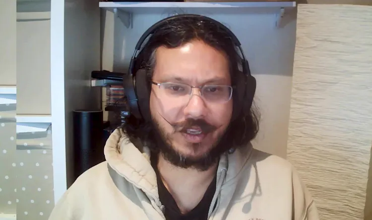 Man with glasses sits in front of computer