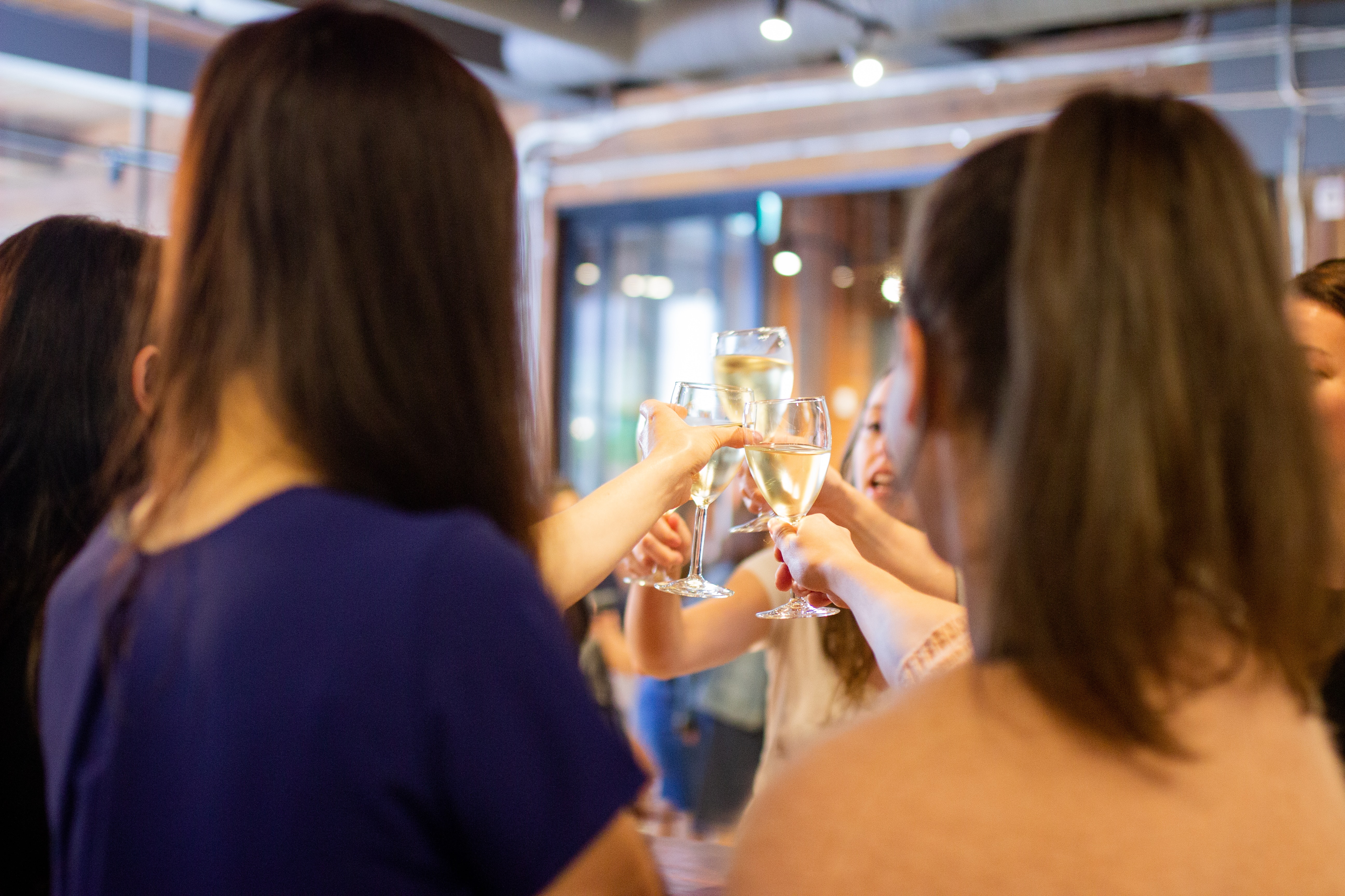 A circle of people clinking champagne glasses