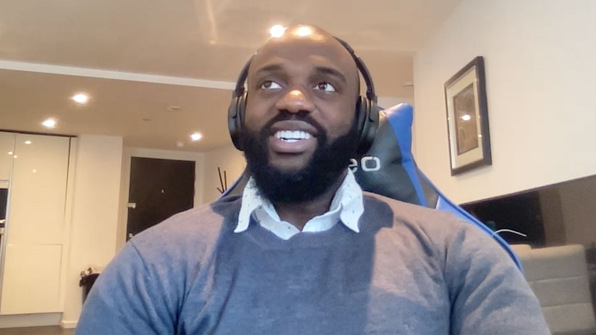 Smiling man sits in front of computer