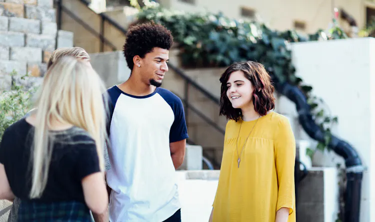 Three young people standing outside a building