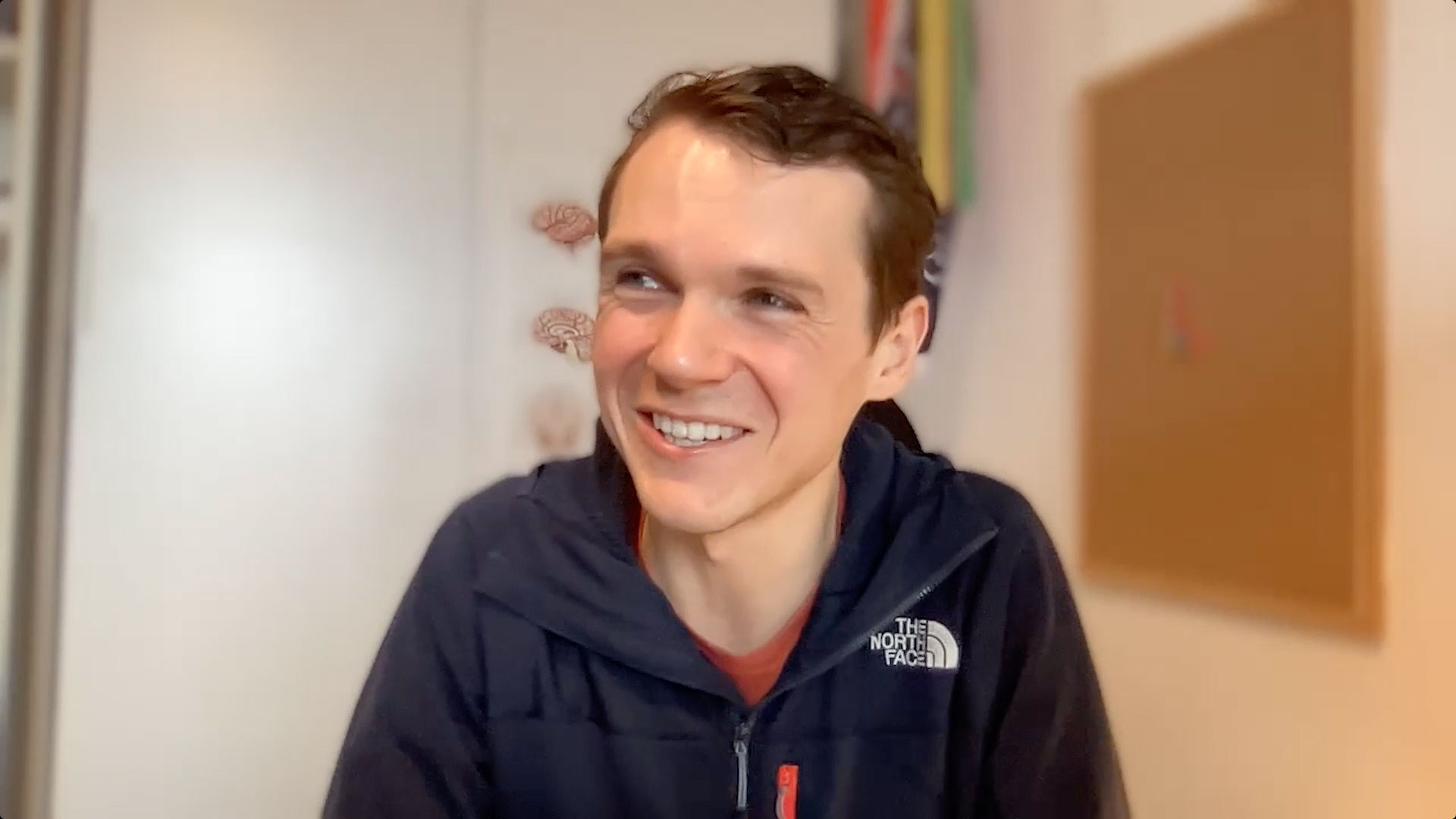 Smiling man sits in front of computer