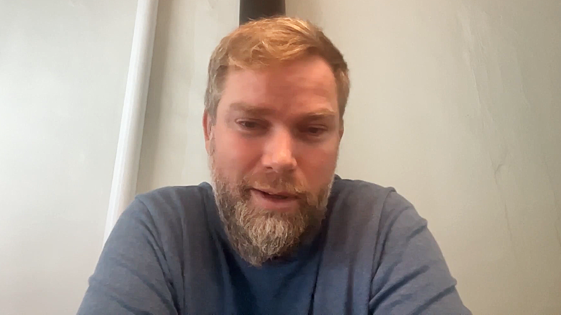 Man with beard smiles at computer