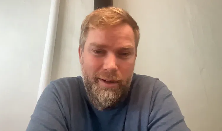Man with beard smiles at computer