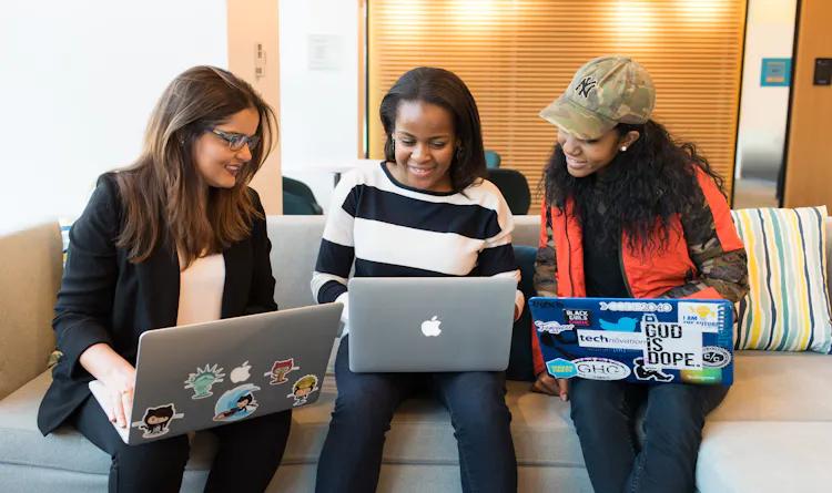 Cover of Three women sitting on a sofa with laptops article
