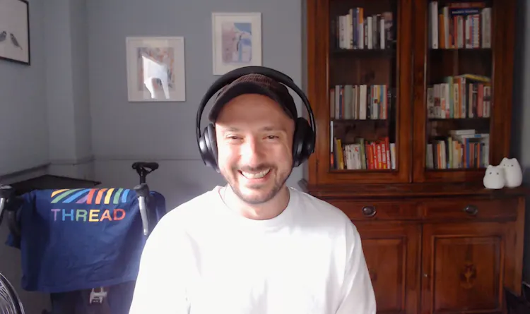 Man smiles sitting in front of a computer