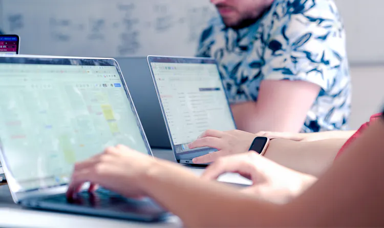 Cover of Two laptops sitting on an office table article