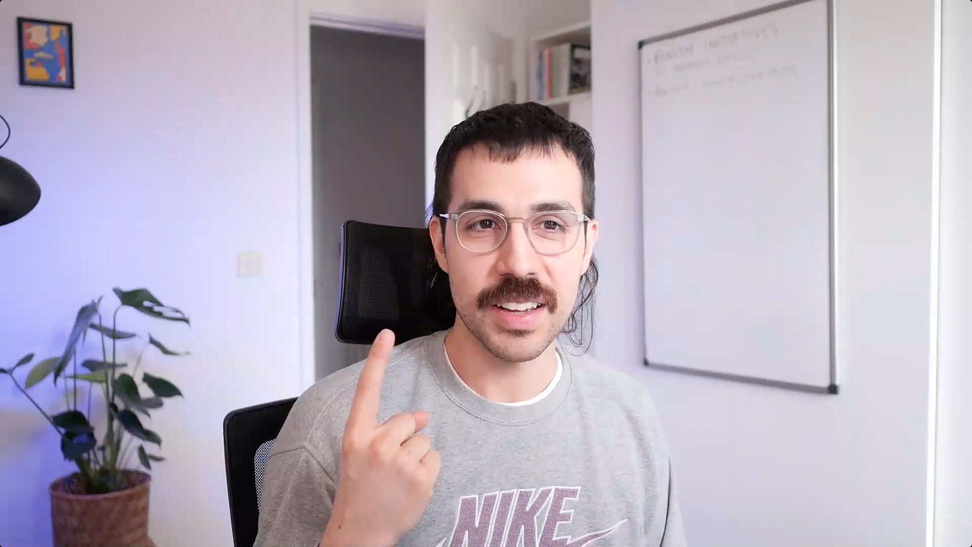Man with glasses sits in front of computer