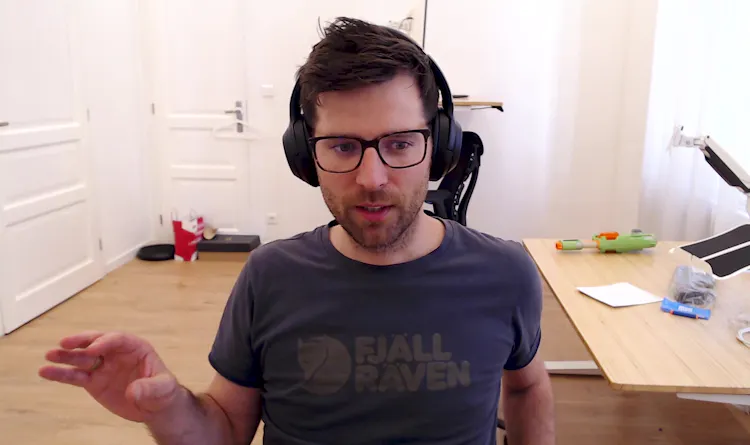 Man with glasses sits at computer