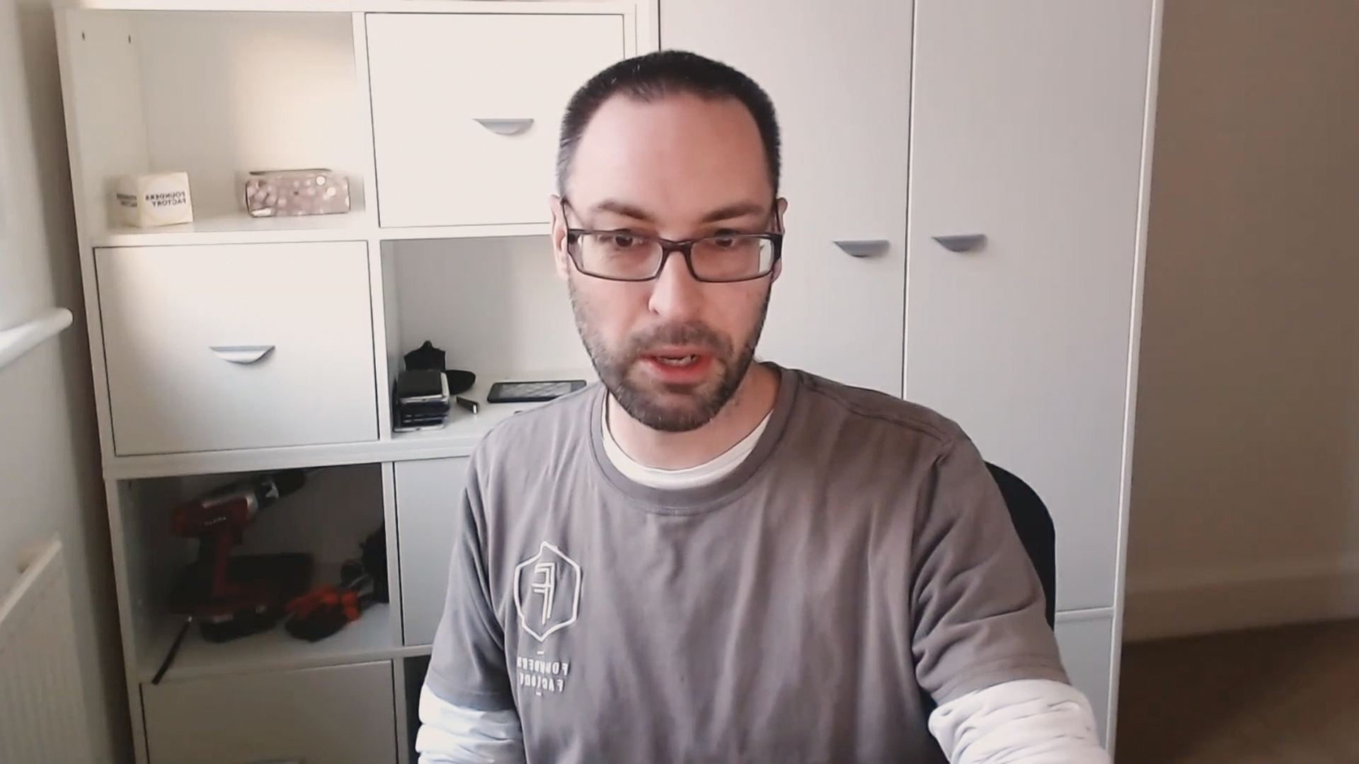 Man wearing glasses sits in front of computer