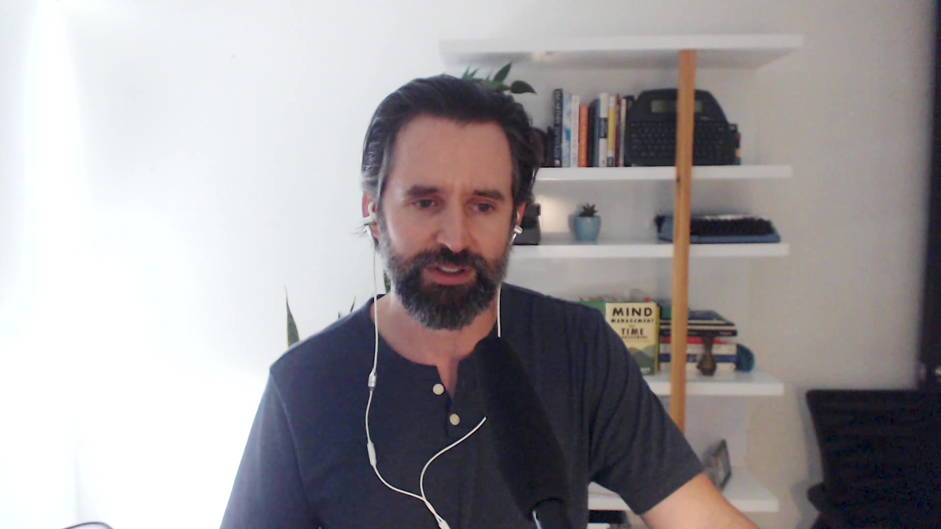 Man with beard sits in front of computer
