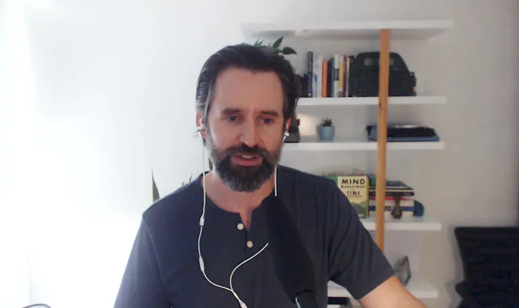 Man with beard sits in front of computer