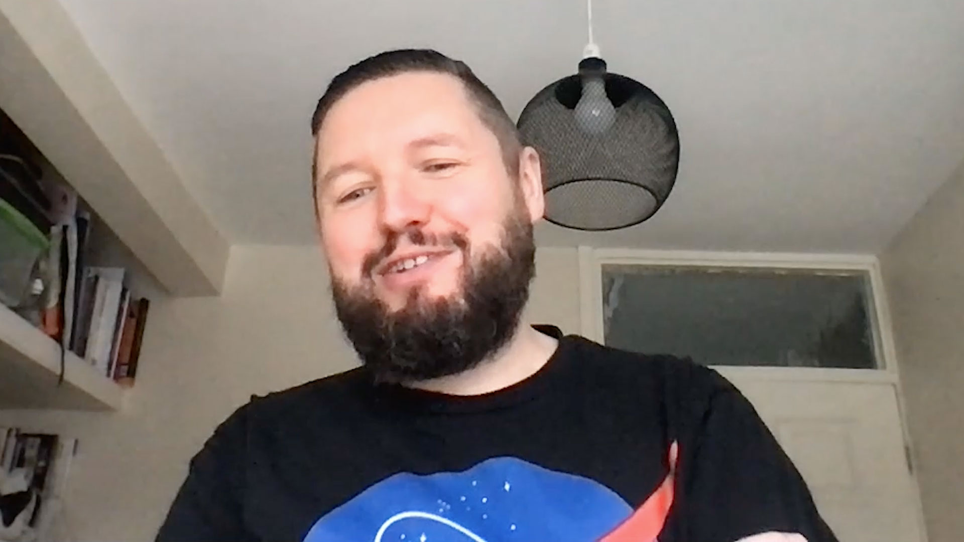 Smiling man stands in front of computer