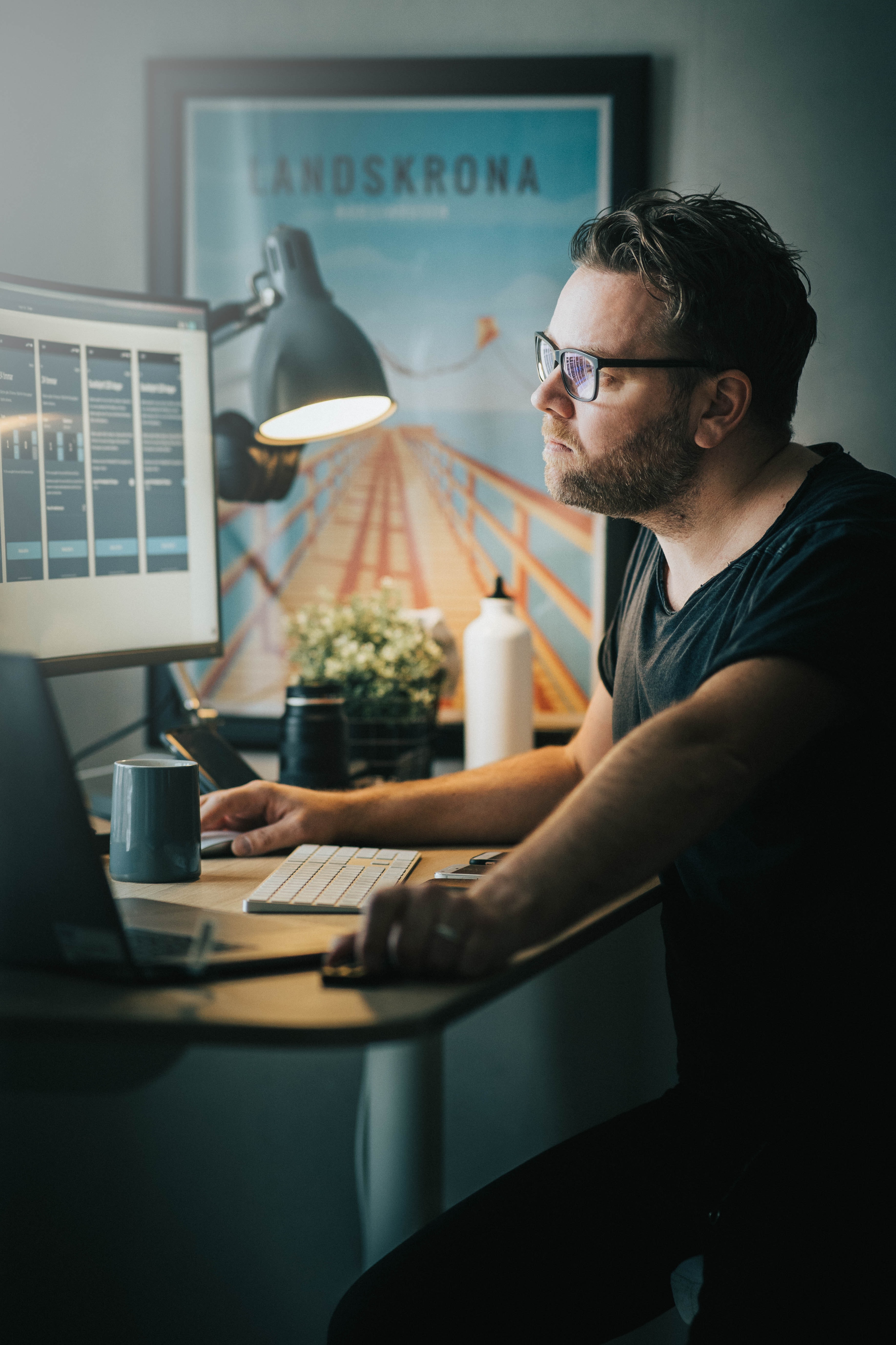 Cover of Man sitting at a desk looking at a monitor with several preview images on it article