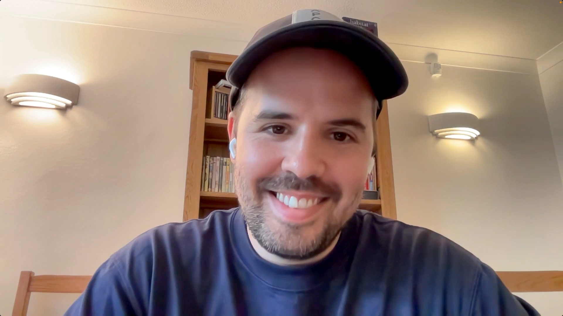 Smiling man sits in front of computer