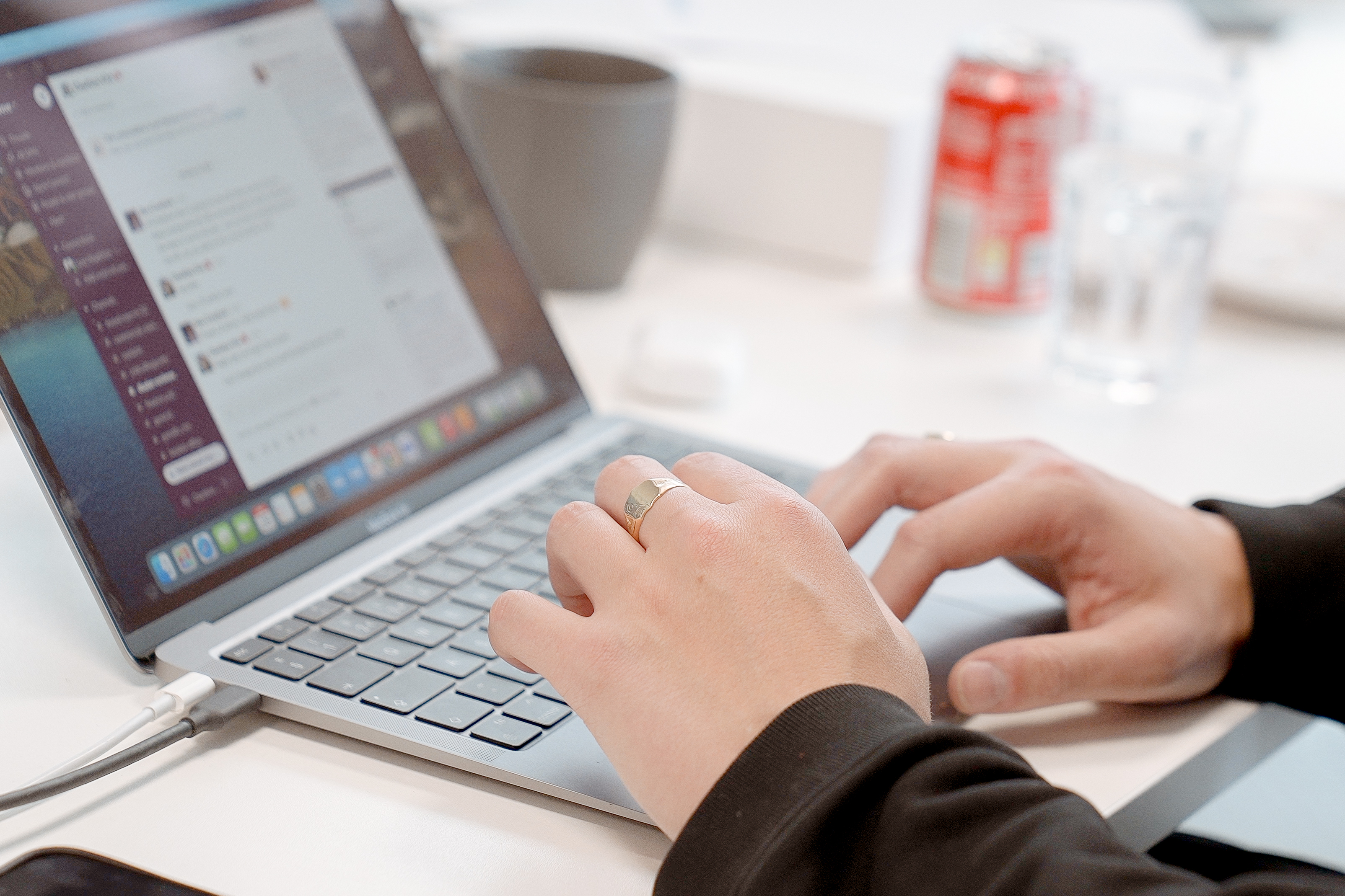 A person's hands at a laptop on a desk