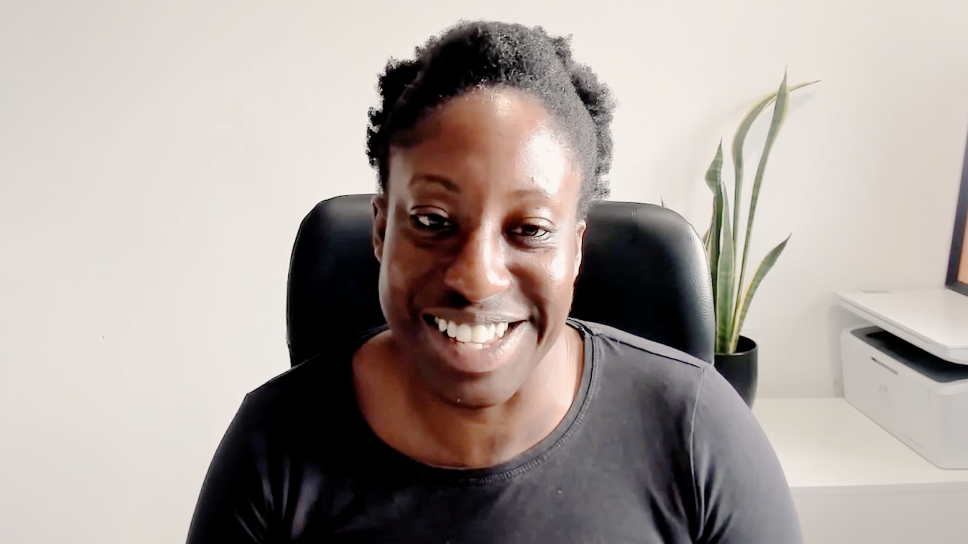 Woman smiles sat in front of computer
