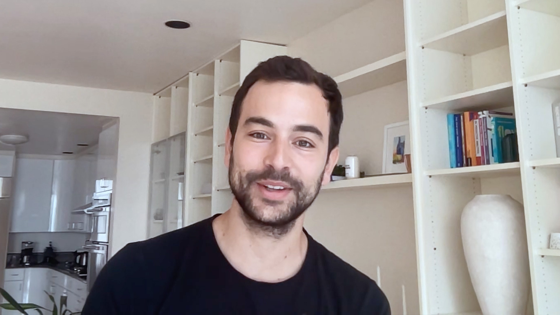 Smiling man stands in front of desk