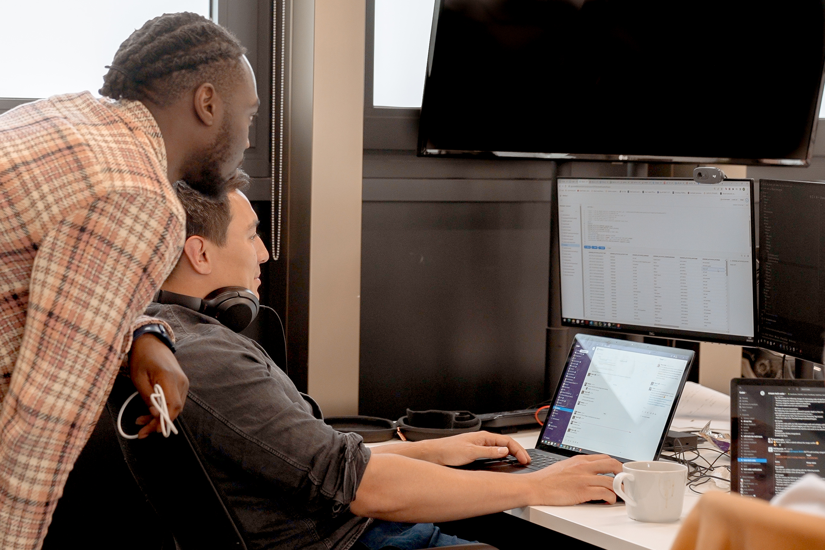 Cover of Two men at an office desk looking at software code on a monitor article