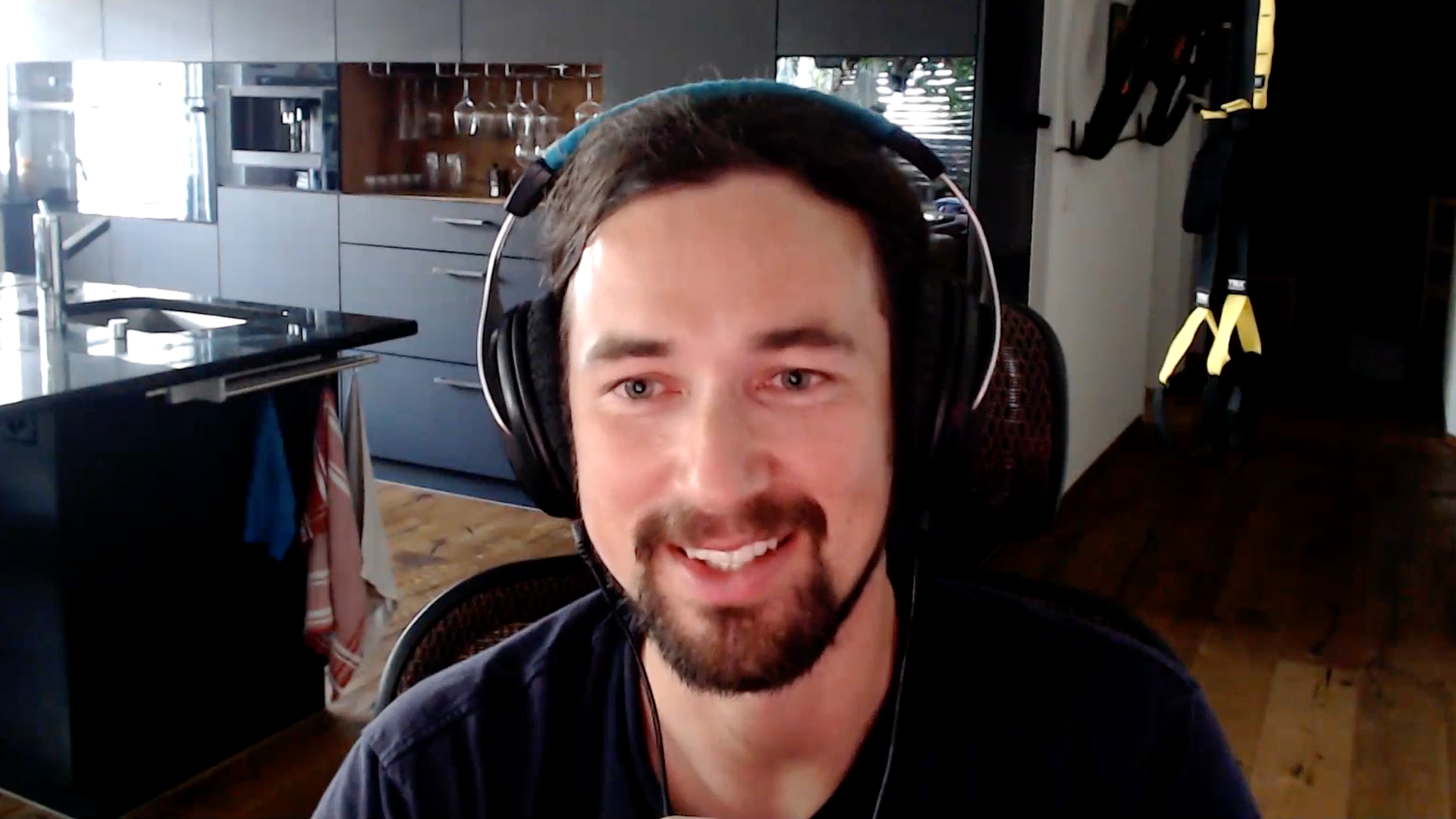 Man wearing headset smiles in front of screen