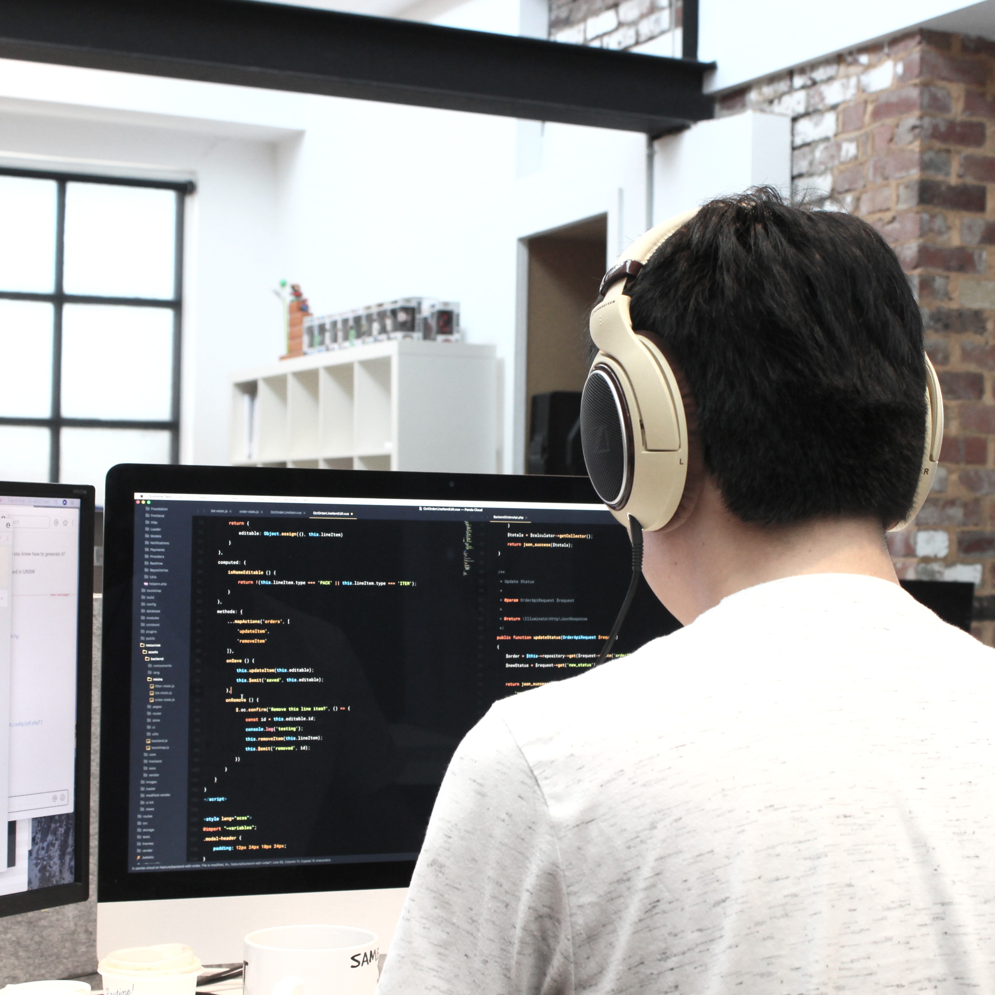 Cover of Person sitting at a screen showing code, wearing headphones article