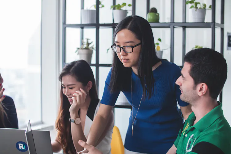 Cover of Three people around a desk looking at laptops article