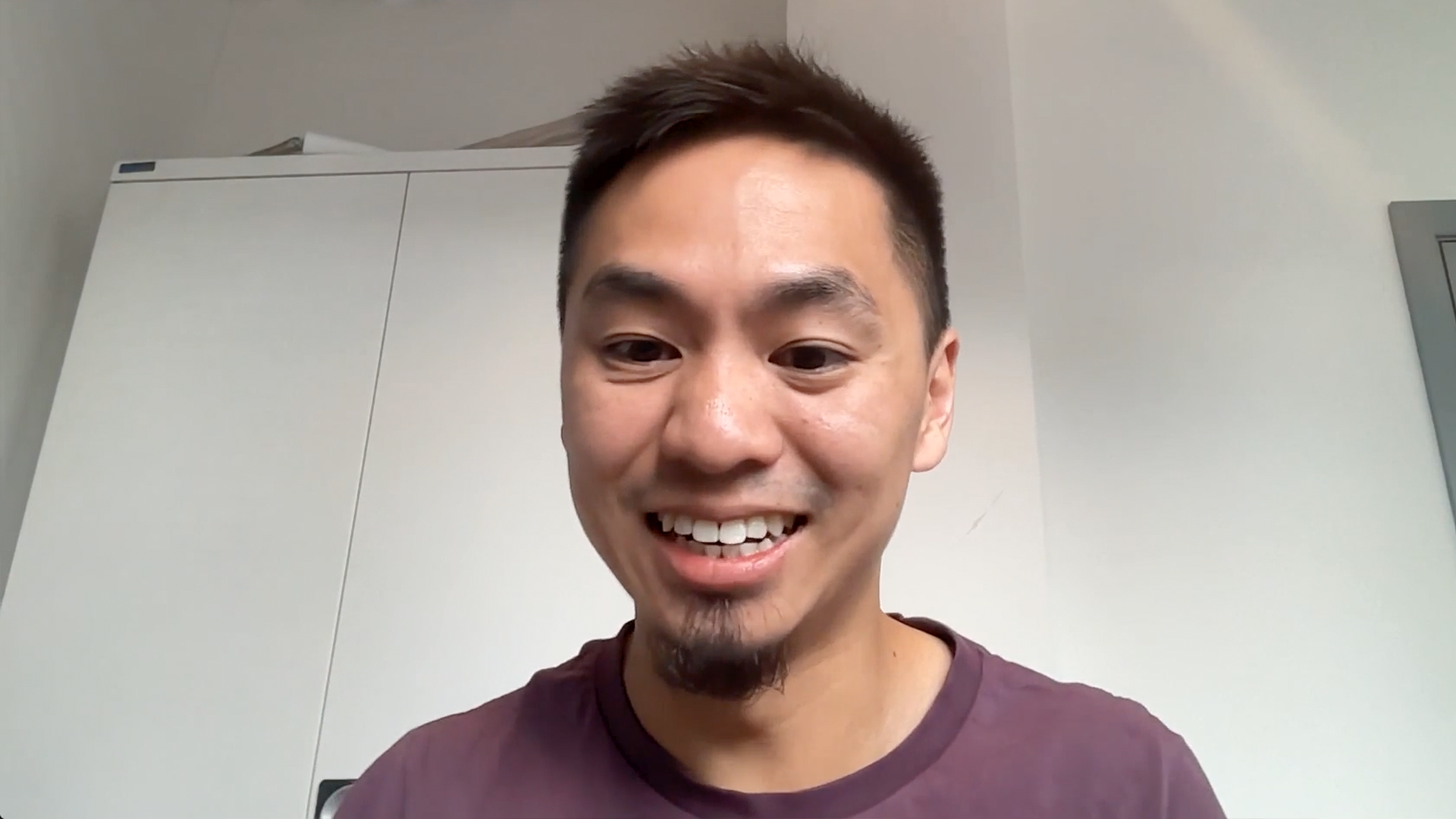 Man smiles sitting at computer