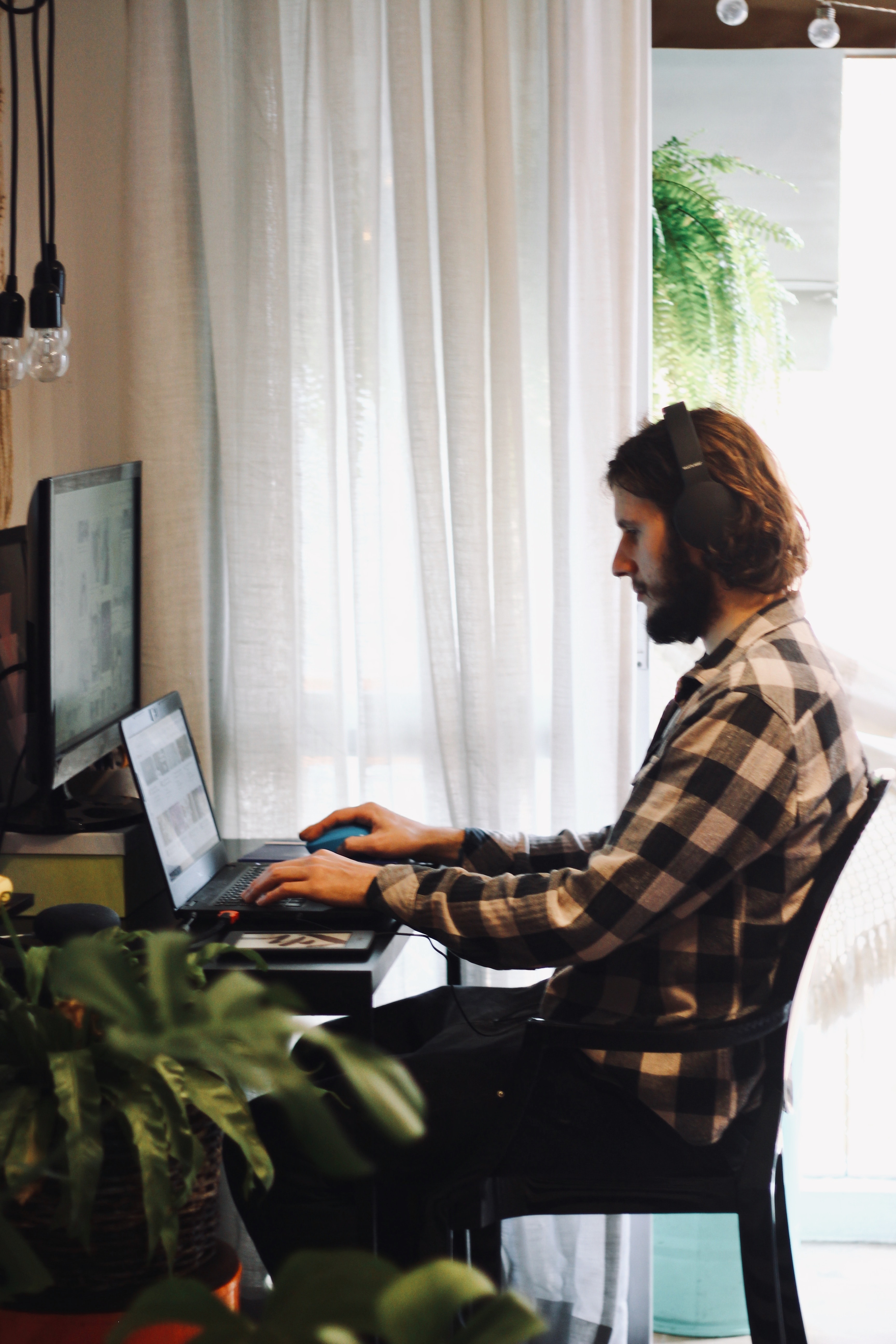 Man wearing headphones sitting at a desk in a home office