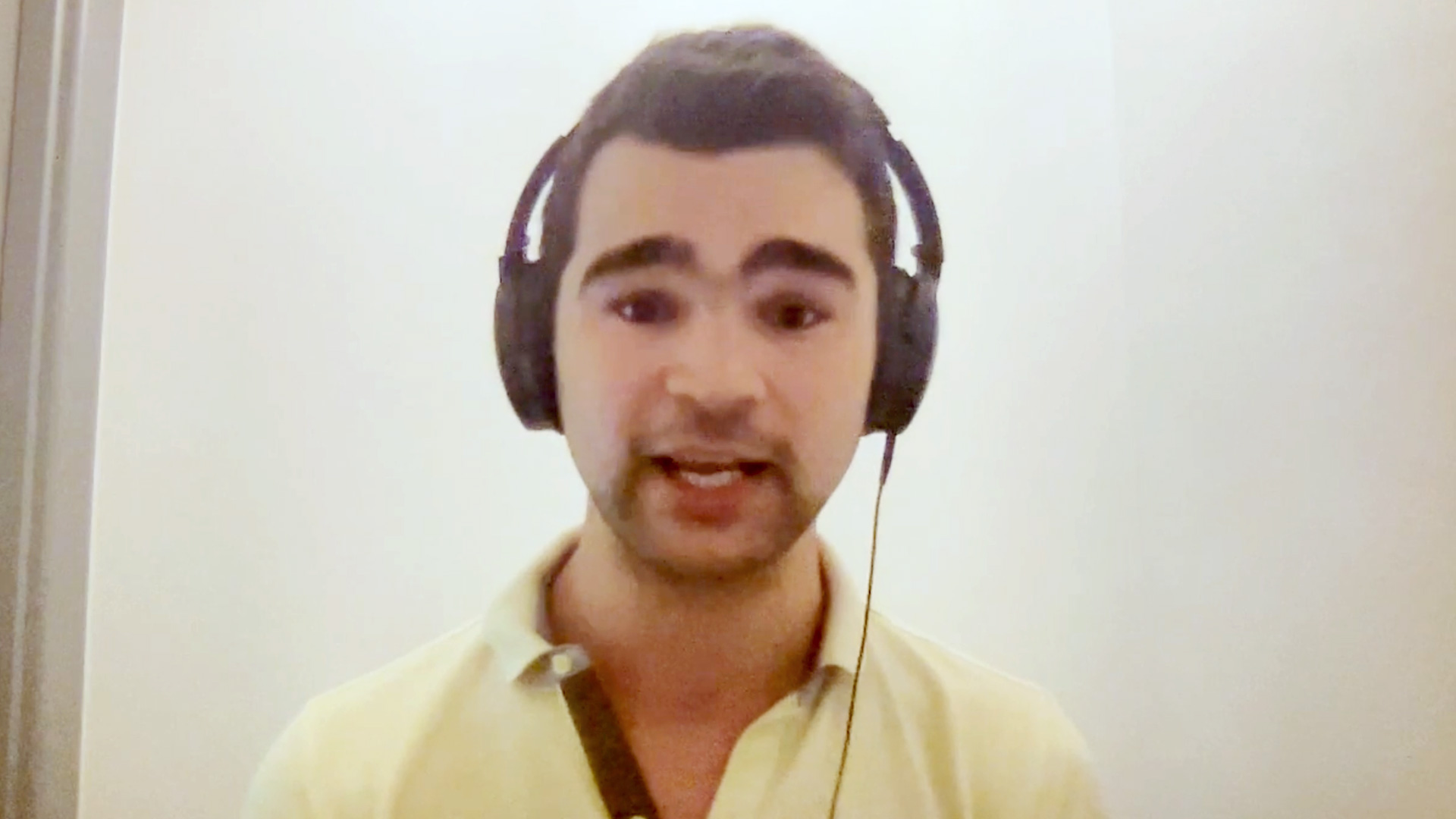 Man wearing headphones sits in front of computer