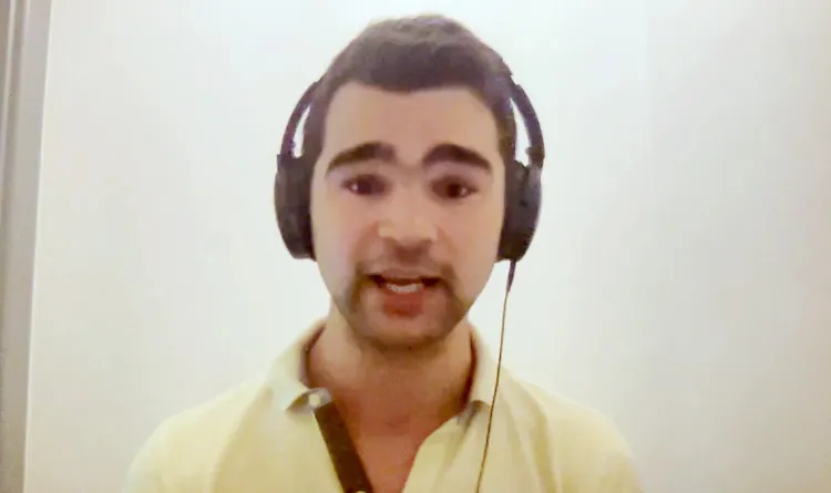 Man wearing headphones sits in front of computer