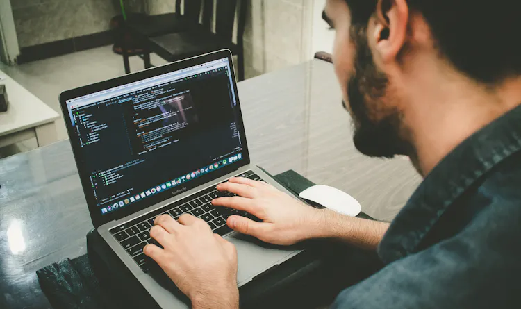 Man working on code on a laptop