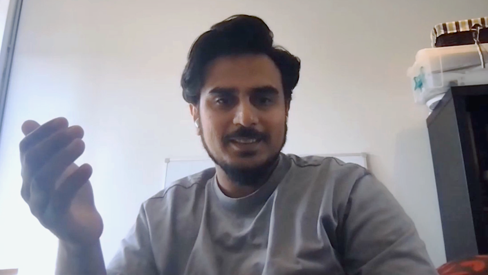 Man with earphones smiles in front of computer