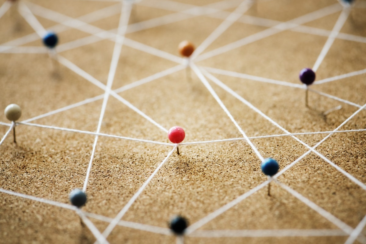 corkboard map with pins and strings