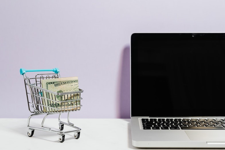 Shopping cart next to laptop with data 